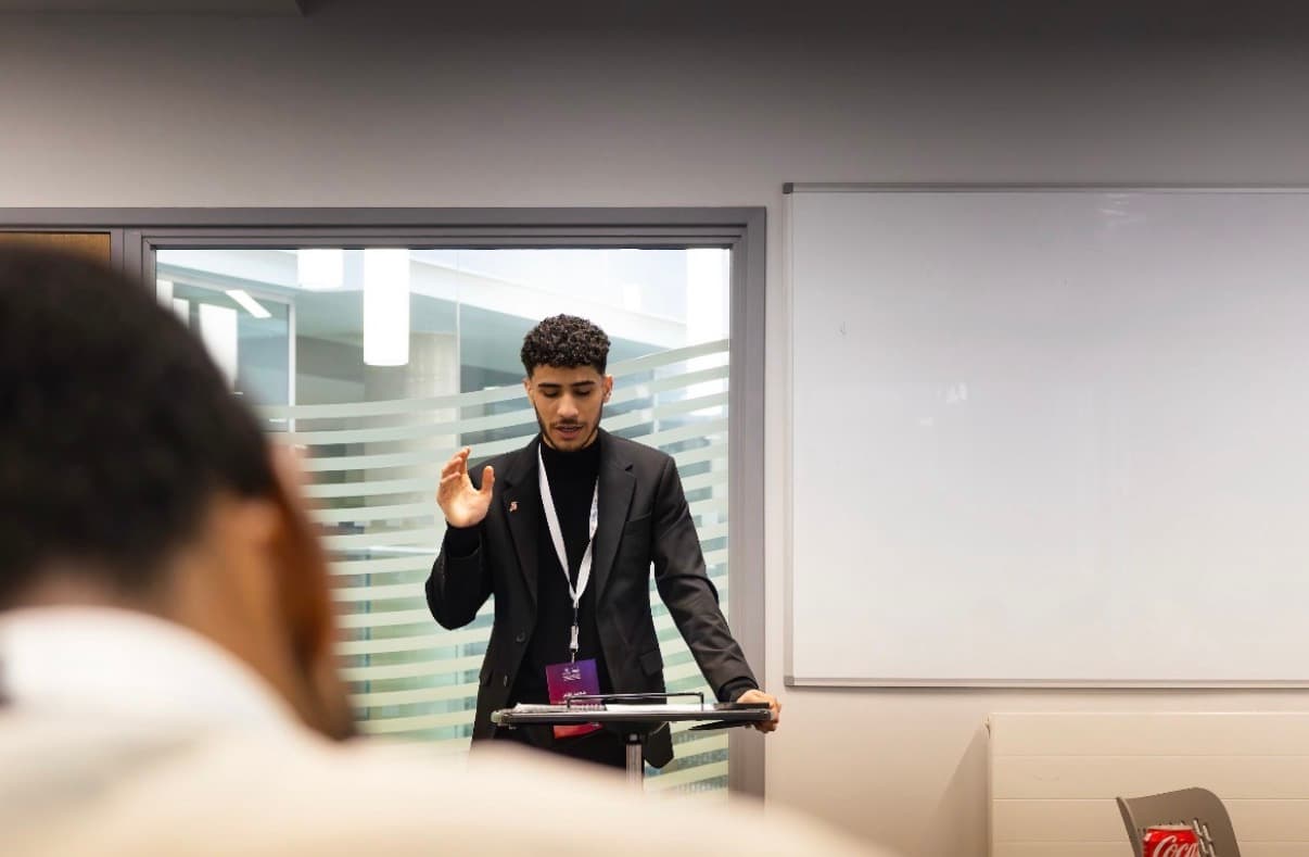 Delivering a speech at the lectern during the QatarDebate championship in Liverpool